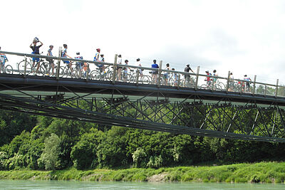 Radfahrerinnen auf Brücke über Fluss