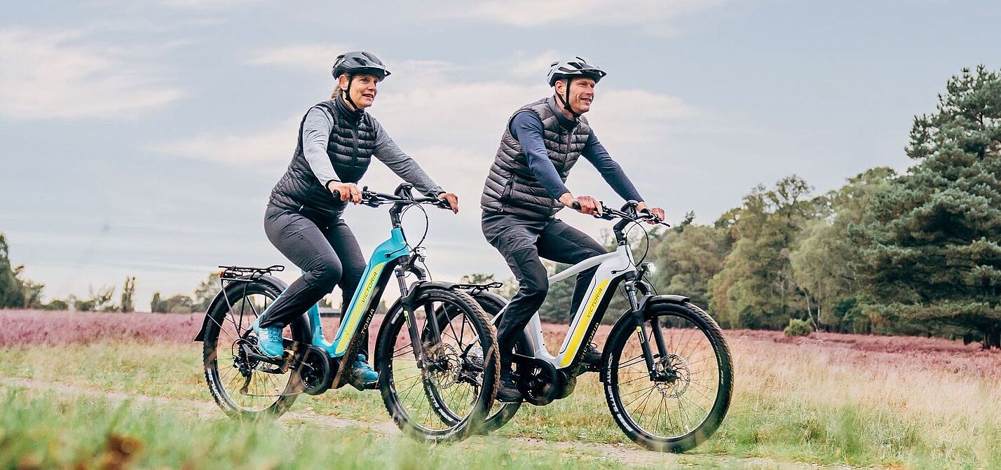 Victoria Lifestyle Mann und Frau auf Elektrofahrrädern in ländlicher Umgebung.